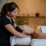 Massage parlor in Tysons Corner featuring a professional therapist providing a relaxing neck and shoulder massage to a client in a serene spa setting.